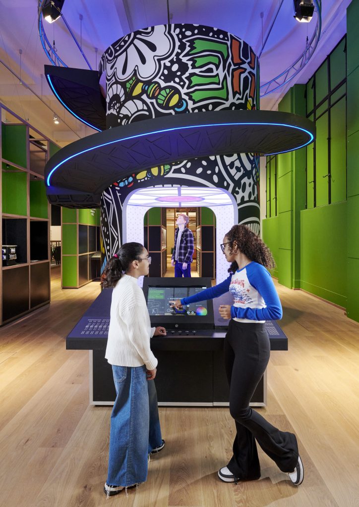 Two teenage girls standing in front of a computer screen, adjusting the lighting for a special effects scene in a film.